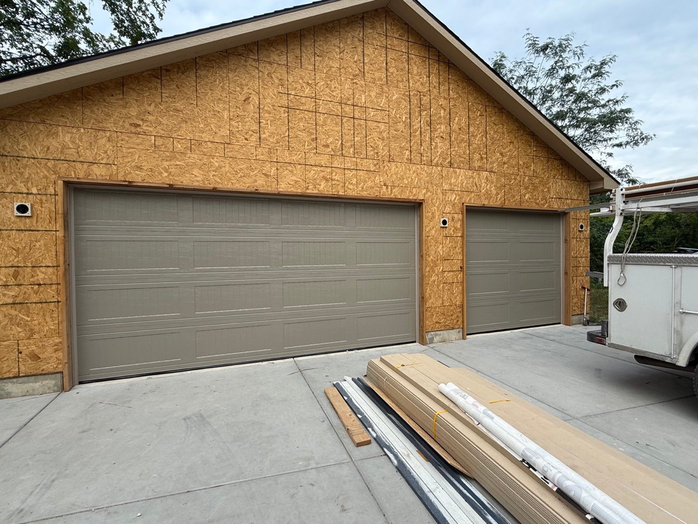 Two sandstone ribbed garage doors on new construction